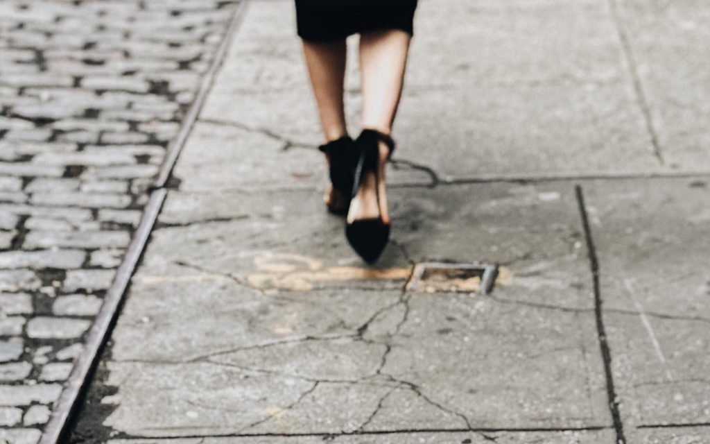 decorative image: woman walking down sidewalk