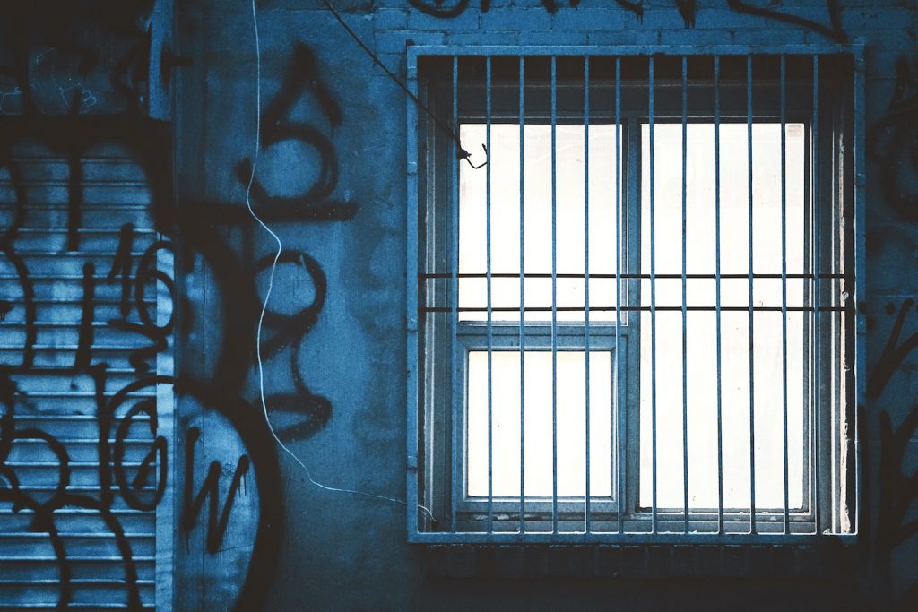 decorative image: graffiti and a barred window. 