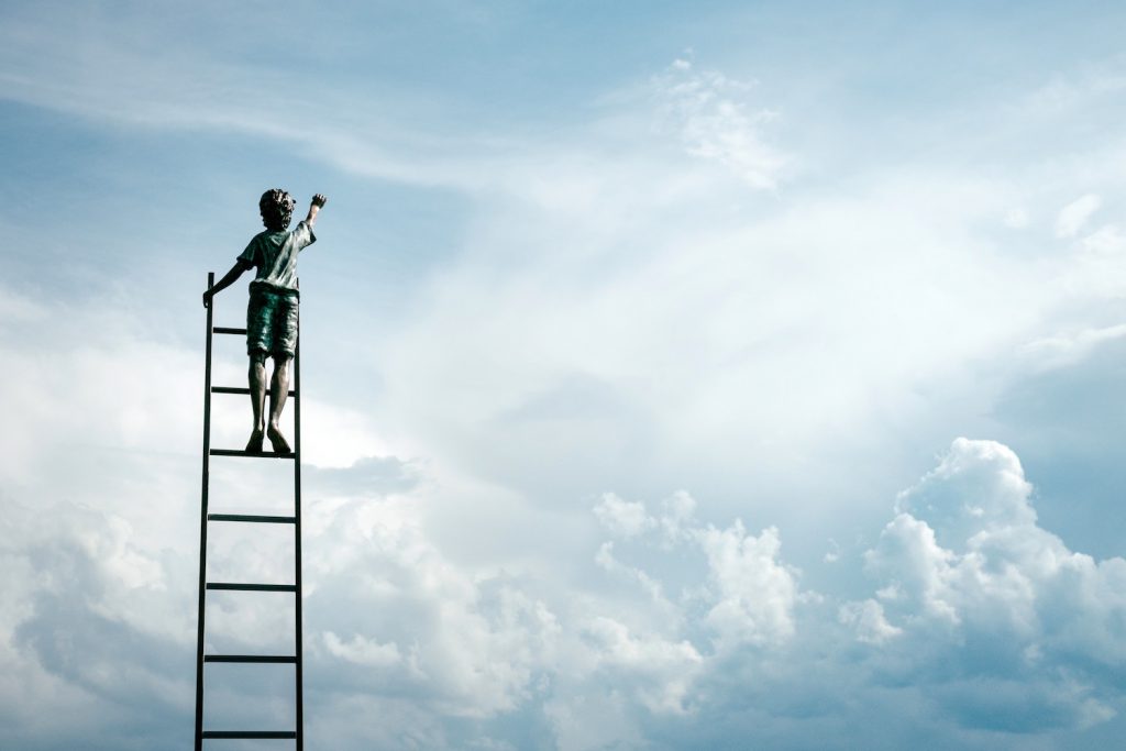 decorative image: boy on ladder reaching for clouds