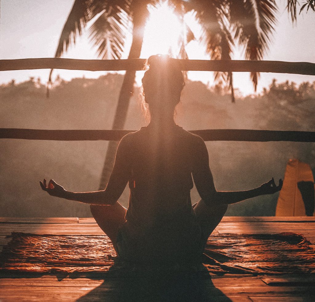 decorative image: woman doing yoga meditation on brown parquet flooring