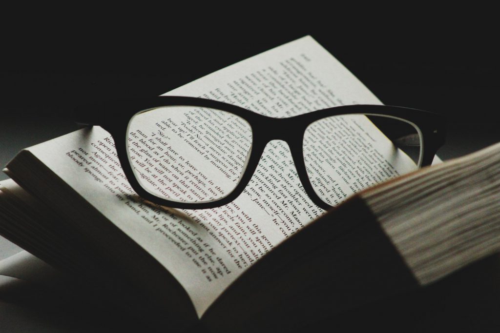 decorative image: glasses and books